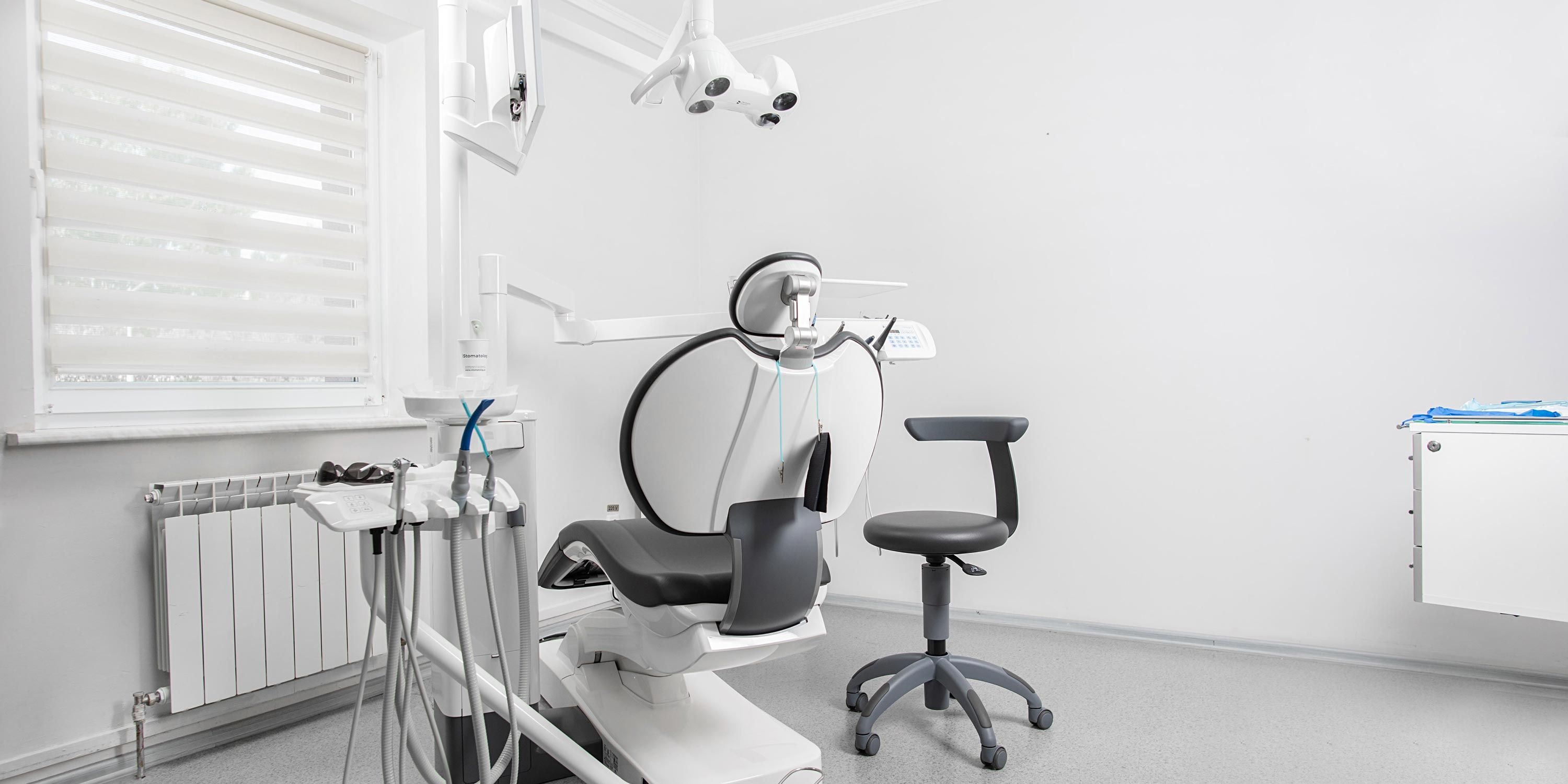 clean dentists office with white walls and chair