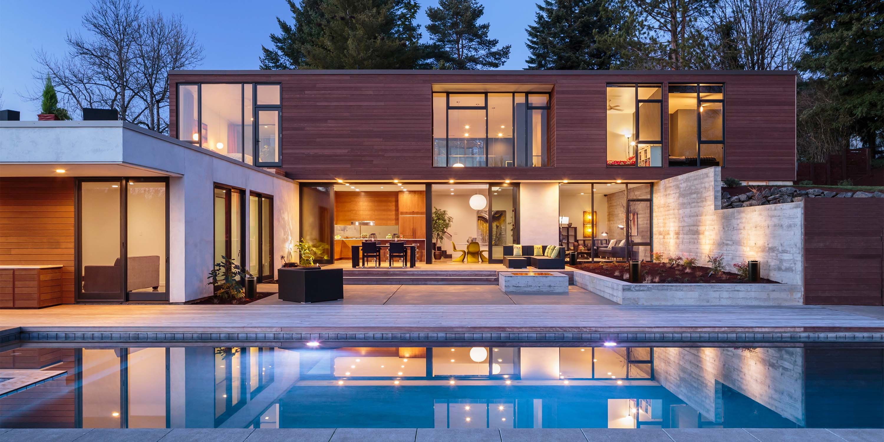 modern home lit up at dusk with leon speakers