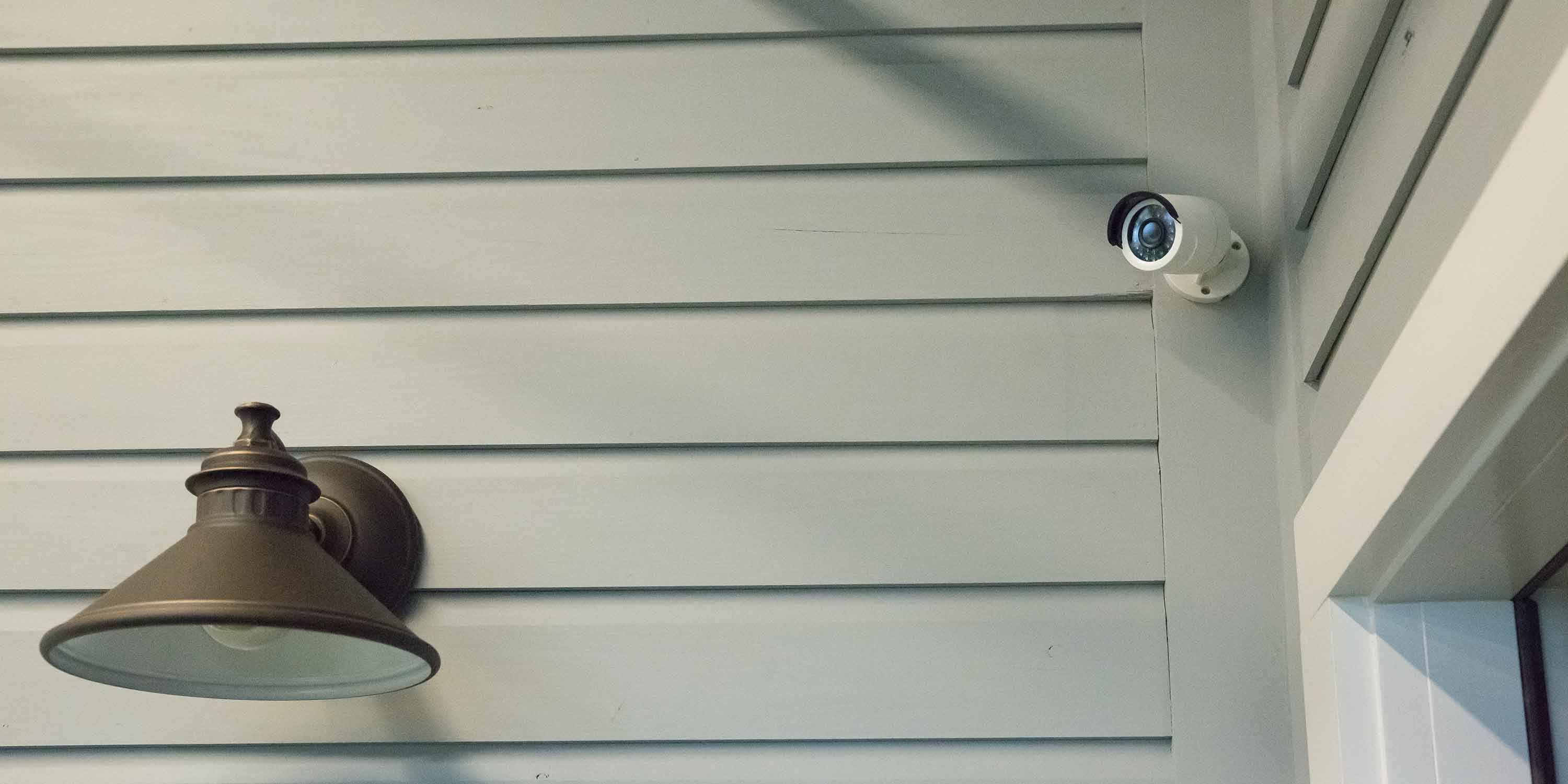 Luma security camera on a pale green siding of a house