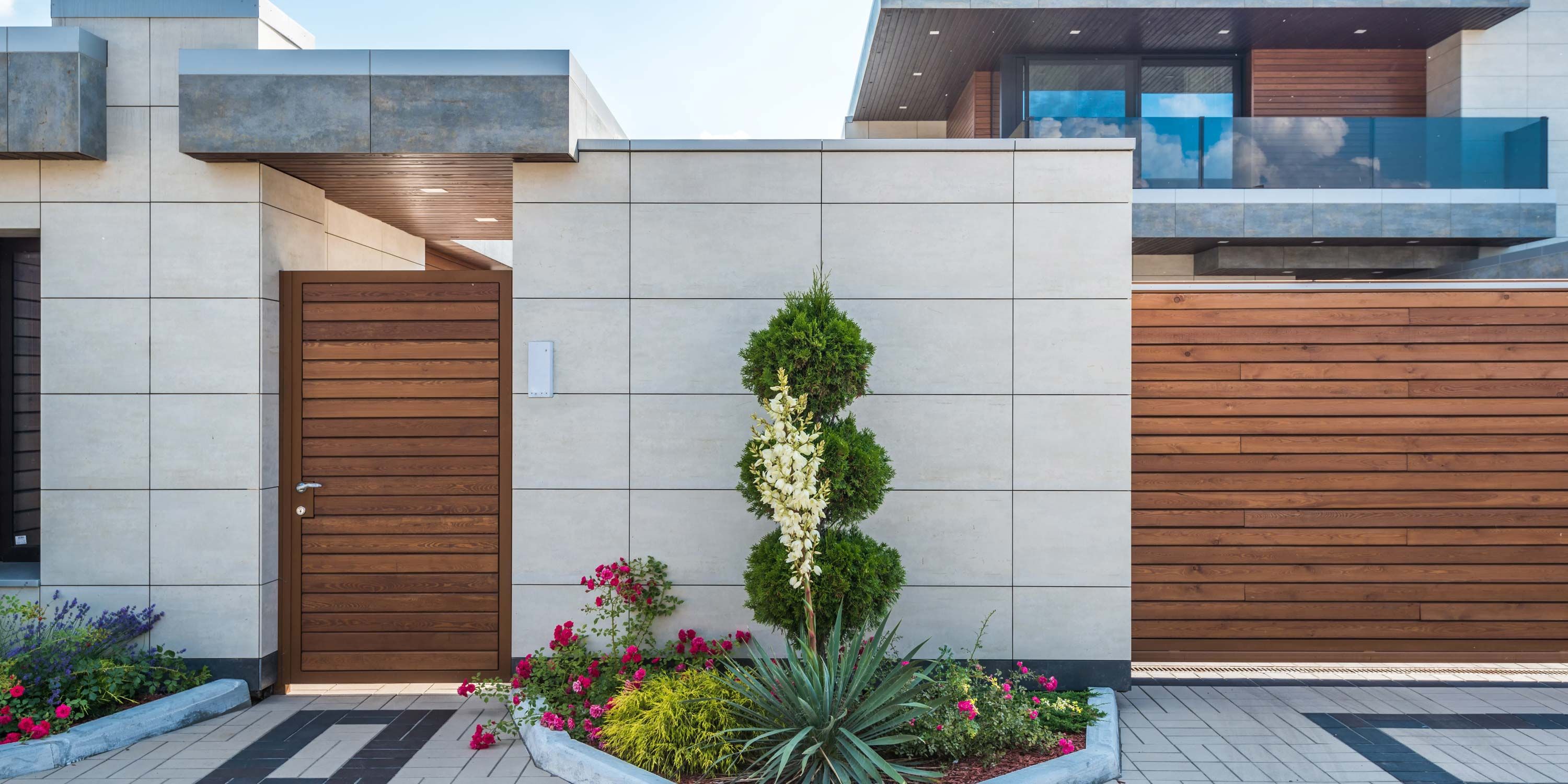 modern home with keypads on wall by gates made of wood