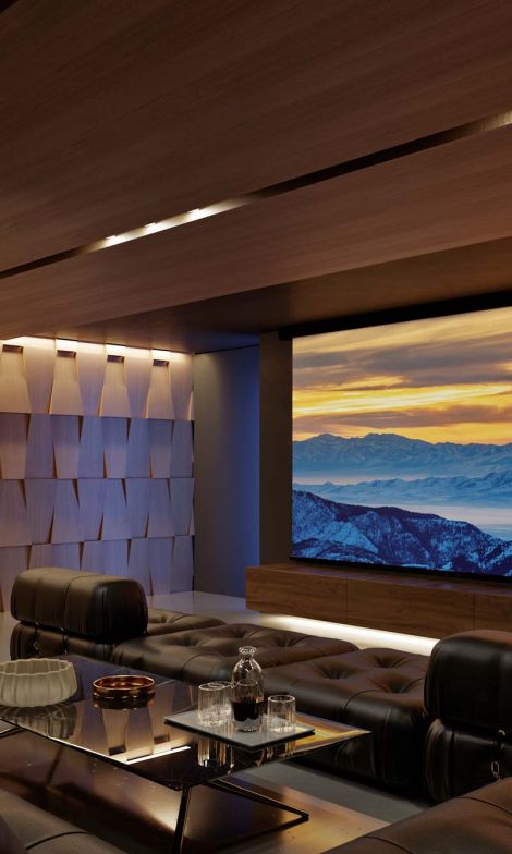 A home theater with Sony technology, a large screen with a mountain scene on it and textured sound paneling