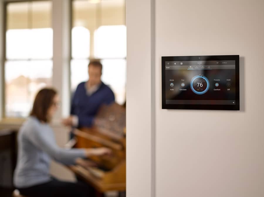 A Control4 interface featuring AV and climate control options onscreen.