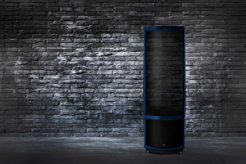 Shot of blue Neolith speakers with a silver brick wall background.